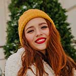 A woman with red hair wearing a yellow hat.